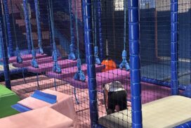 Indoor soft play area featuring padded obstacles, climbing structures and safety netting."