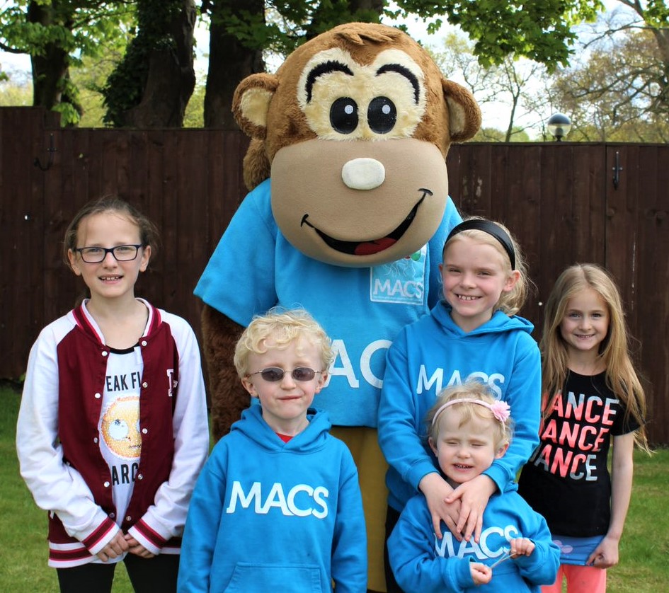 Image shows MACS the Monkey with some children at a MACS event