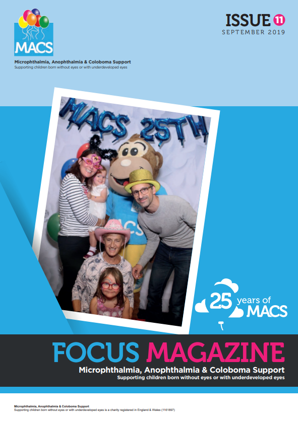 This cover shows a cheerful group posing inside a photo‑booth style frame decorated with the text “MACS 25th” along the top. The group is gathered closely, and one person is holding a large mascot-style head resembling a lion or character figure. The backdrop is bright and festive. The MACS logo appears in the top left, and the top right corner reads “ISSUE 11 2017.” The bottom banner is black and pink with the title “FOCUS MAGAZINE” and the subtitle “Microphthalmia, Anophthalmia & Coloboma Support.” A small circular emblem at the bottom right reads “25 years of MACS.”