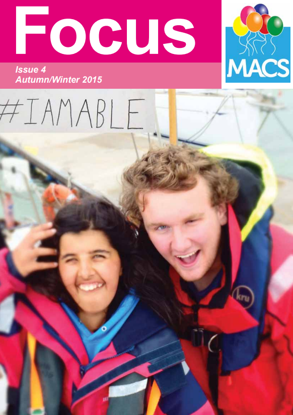 This cover shows two individuals dressed in bright outdoor jackets, standing close together. One of them is holding up a piece of white card with handwritten text that reads “#IAMABLE”. The background suggests an outdoor event or gathering. The top banner is bright pink with the title “Focus”, the text “Issue 4 Autumn/Winter 2015”, and the MACS balloon logo.