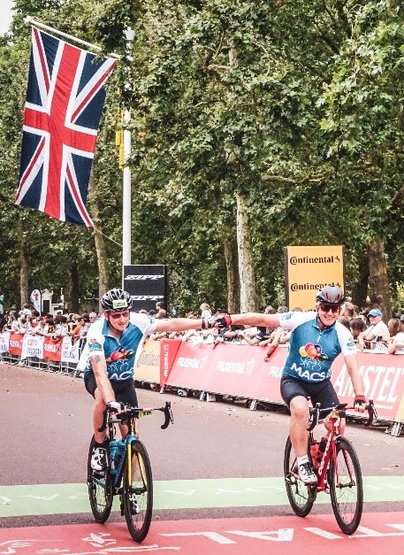 Image shows two MACS riders crossing the finish line